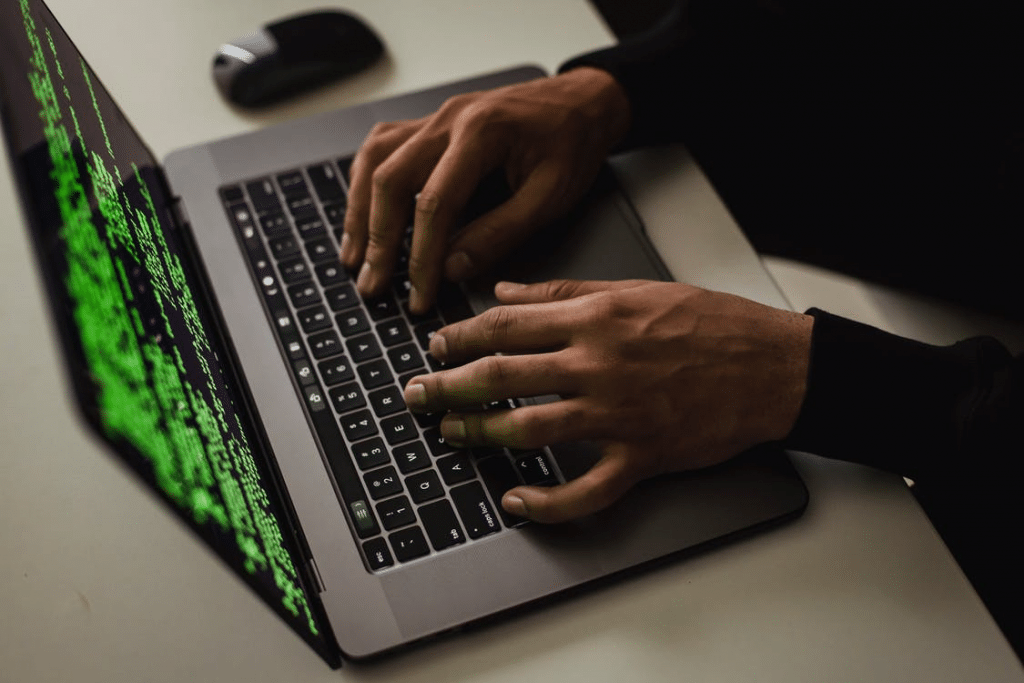 A person typing binary codes on a laptop